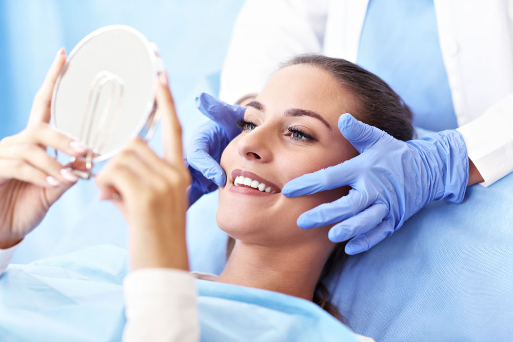 patient checking the result of their teeth smiling